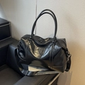 Sleek black faux leather travel bag with high-gloss finish and adjustable shoulder strap - Black