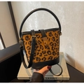 Detail der Bucket Bag mit Leopardenmuster, goldenem Drehverschluss und schwarzem Ledergurt - Schwarz und Braun