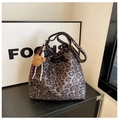 Detail of leopard print bucket bag with drawstring closure and plush bear charm accent - Gray