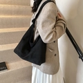 Sac fourre-tout noir mat rétro avec bandoulière nouée porté par un mannequin - Noir