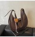 Détail du sac dumpling en cuir litchi marron avec pendentif ours et breloque tissée - Café avec Pendentif