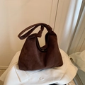Dark brown suede tote bag with knotted shoulder strap on white blazer background - Brown