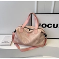 Nahaufnahme der rosa Reisetasche mit Wildlederstruktur, Logo-Prägung und stabilen Griffen - Rosa
