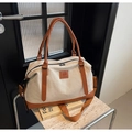 Detail showing durable canvas travel bag with leather accents and secure metal zippers - Brown