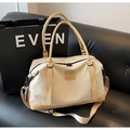 Close-up of stylish canvas travel bag with leather handles and adjustable shoulder strap - Khaki