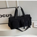 Dettaglio della borsa fitness in nylon nero con tasche laterali a fibbia e manici - Nero