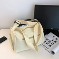 Macro detail of the spacious beige nylon gym bag with side shoe compartment on a desk - Yellow