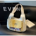 Detalle del bolso tote de lona crema con bolsillo amarillo con solapa y ventana de PVC - Blanco Roto