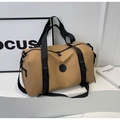 Detail of khaki large travel bag with wide black handles and buckle straps on a white stand - Khaki