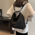 Grande borsa a secchiello in pelle scamosciata nera opaca indossata dalla modella - Nero