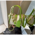 Detalle del bolso de cubo bicolor con asa de pañuelo de seda y cierre de metal dorado - Verde