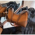 Macro view of caramel brown hobo bag showing contrast of smooth leather and suede textures - Brown