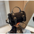 Detail of black plush faux fur shoulder bag with golden hardware and matte texture finish - Black