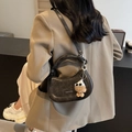 Vintage schwarze Halbmonden-Satteltasche aus mattem Leder mit Plüschbären-Anhänger - Schwarz