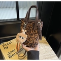 Mini sac seau à imprimé léopard avec lanières en cuir marron et breloque poupée peluche - Imprimé Léopard Brun Avec Pendentif