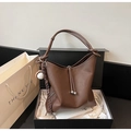 Details einer dunkelbraunen Leder-Beuteltasche mit Baseball-Anhänger in Geschenkbox - Kaffee mit Anhänger