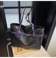 Detail view of black leather tote bag with contrasting purple handles and metallic buckle - Black and Purple