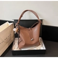 Detail einer braunen Leder-Beuteltasche mit Kordelzug und Baseball-Anhänger in einer Geschenkbox - Braun mit Anhänger