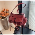 Detail van bordeauxrode laklederen baguette-tas met trekkoorden en zijvakje - Rood
