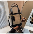 Dettaglio della borsa a secchiello con texture in tela pelle e ciondolo mostro - Patchwork Beige Nero Con Ciondolo