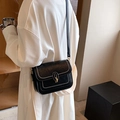 Elegante borsa a tracolla nera con cuciture bianche e chiusura oro su cappotto bianco - Nero