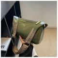 Dettaglio borsa a bauletto verde scuro con pelle cerata e ampia tracolla intrecciata - Verde