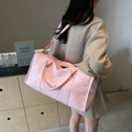 Pink large capacity travel bag in glossy faux leather with adjustable strap shown on model - Pink