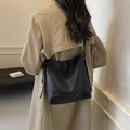 Elegante borsa a secchiello intrecciata nera indossata con trench kaki per pendolari - Nero