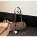 Detail der dunkelbraunen Wildleder-Zylindertasche mit Reißverschluss und Baseball-Anhänger - Kaffee mit Anhänger