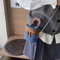 Mini bolso de cubo cilíndrico en denim y cuero marrón con cadena dorada en el modelo - Azul oscuro