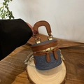 Mini bolso tipo cubo de mezclilla azul con ribete de cuero marrón y cadena dorada - Negro