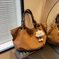 Retro tan canvas tote bag with brown straps, silver eyelets, and cloud plush charm - Brown