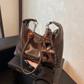 Dark brown leather handbag with amber beads and a cat charm on a black stand - Dark Coffee