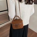 Quilted caramel brown vanity bag with chain strap and handle shown on model shoulder - Brown