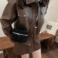 Chic black quilted mini crossbody bucket bag with chain strap shown on a model - Black