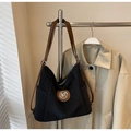 Détail d'un sac cabas en nylon noir avec bandoulière en cuir marron et logo M argenté - Noir