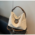 Gros plan détaillé d'un grand sac cabas avec logo M métallique et poche latérale - Blanc Cassé