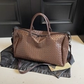 Dark brown woven leather travel bag with dual handles and adjustable shoulder strap - Brown
