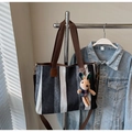 Detailed view of canvas tote with vertical stripes and cute plush rabbit charm accessory - Black with Pendant