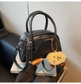 Detail der schwarzen Handtasche aus Narbenleder mit weißen Nähten und Plüsch-Anhänger - Schwarz