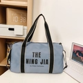 Hellblaue Reisetasche aus Nylon mit schwarzen Griffen und THE NING JIA Schriftzug - Blau