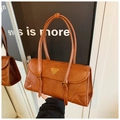 Detailansicht der braunen Baguette-Tasche aus Kunstleder mit Metallschnalle und Plakette - Braun