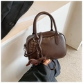 Detail of dark brown Boston bag with leather texture, silver zipper and bird charm - Coffee with Pendant