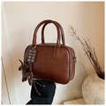 Close-up of vintage brown boston bag with a cute dog pendant and textured PU leather - Red with Pendant