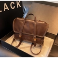 Gros plan du sac cabas vintage en cuir marron avec boucles et texte embossé en boîte - café