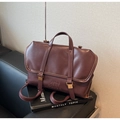 Détail du cabas vintage en similicuir marron foncé avec logo embossé et boucle dorée - Bordeaux