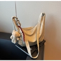 Detailansicht der beigen Wildleder-Hobotasche mit Plüschbären-Anhänger und Kordelakzent - Khaki (Mit Anhänger)
