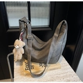Detail der grauen Hobo-Tasche mit Plüschbären-Anhänger auf Marmoroberfläche - Dunkelbraun (Mit Anhänger)