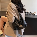 Schwarze Retro Hobo-Tasche aus Leder mit Silberkette am Modell für den täglichen Weg - Schwarz