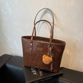 Dunkelbraune matte Leder-Tote-Bag mit Plüschbär-Anhänger und Quasten-Detail - Braun